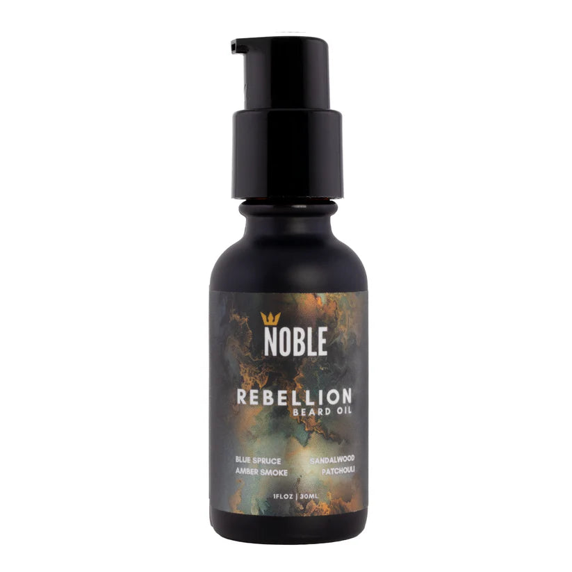 Bottle of Noble Rebellion Beard Oil on a white background. Noble Product Rebellion Beard Oil – skin-first hydration with Jojoba, Argan & Cloudberry Seed Oil, bold smoky wood scent, 1oz | Urban City Barbershop