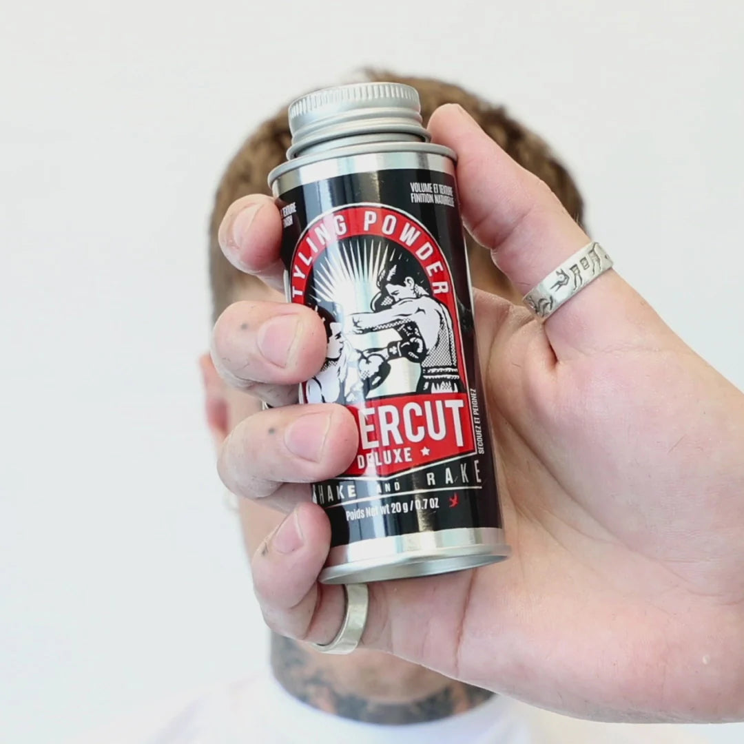 Hand holding a can of styling powder against a neutral background. Uppercut Styling Powder held up close – lightweight hair texturizing powder for men's crops and quiffs