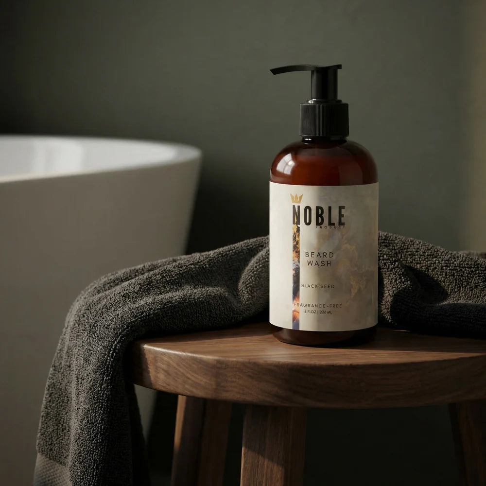 Bottle of Noble Beard Wash on a wooden stool with a towel in a bathroom. Noble Product Beard Wash – Sulfate-Free Formula for Sensitive Skin and Coarse Beard Hair setting