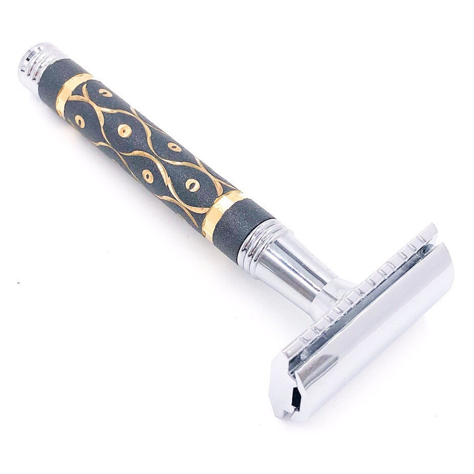 Shaving razor with decorative handle on a white background. Parker 65R three-piece safety razor – black and gold brass handle with sandstone texture