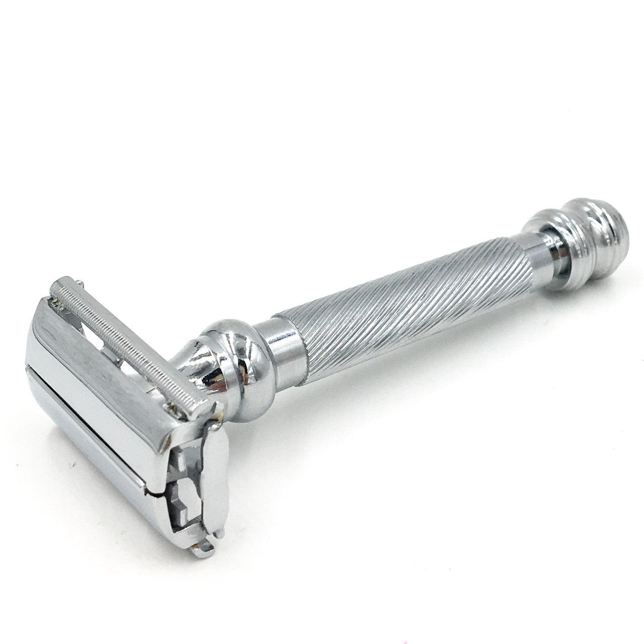 Silver safety razor on a white background. Parker 99R razor handle close-up – knurled brass with chrome plating
