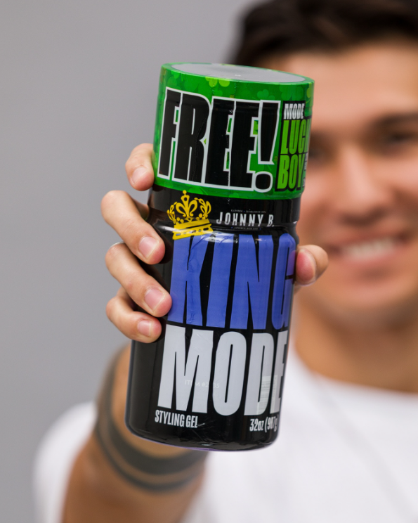 Person holding a bottle of Johnny B King Mode styling gel with a gray background.. Johnny B. King Mode Styling Gel 32oz bundle with Lucky Boy 12oz Gel – professional strong hold hair gel