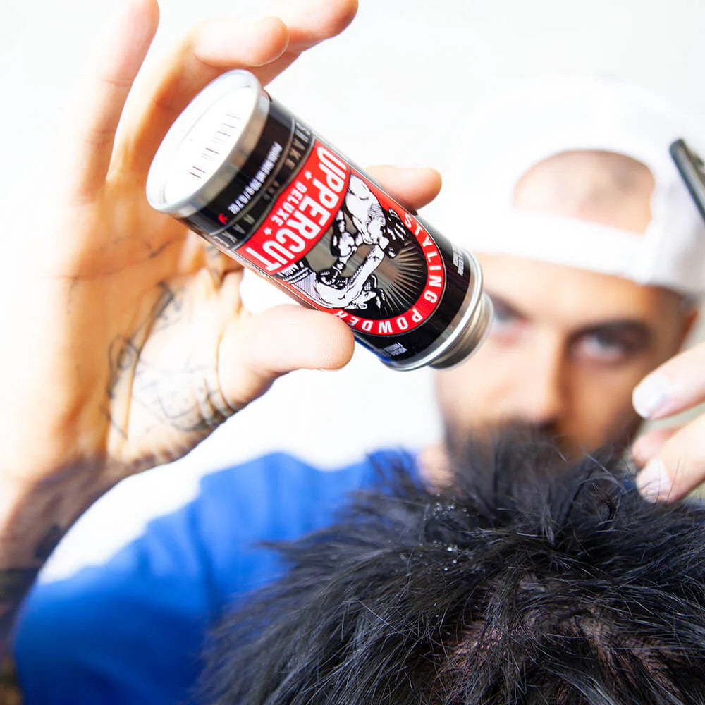 Person applying a can to another person's head. Man styling hair with Uppercut Styling Powder – adding volume and texture to short hair, flexible hold